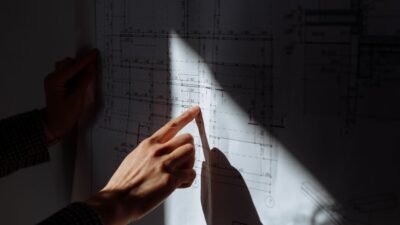 Business owner's hands carefully using a ruler and pen to draw a precise line on a business plan, symbolizing marketing me...